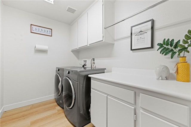 32177 Clear Springs Dr, Winchester, CA 92596 - laundry area featuring cabinet space, washing machine and clothes dryer, and light wood finished floors