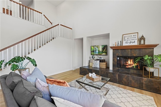 32177 Clear Springs Dr, Winchester, CA 92596 - living area with wood finished floors, a towering ceiling, stairway, and a tiled fireplace