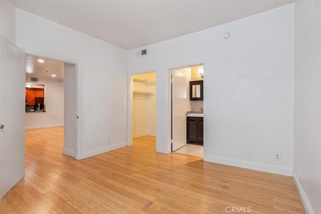 spare room with light wood-type flooring and baseboards