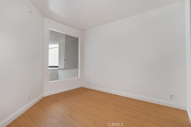 unfurnished room with light wood-style floors and baseboards