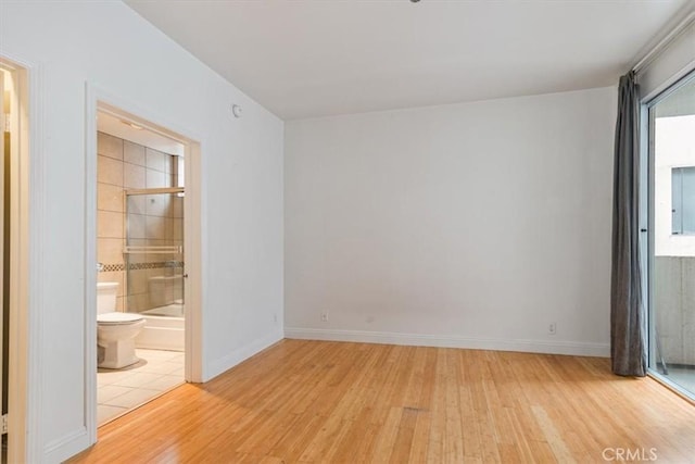 unfurnished room with light wood-style flooring, baseboards, and electric panel