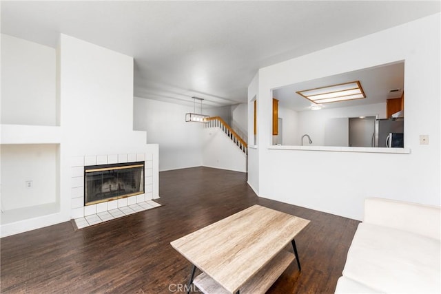 unfurnished living room with a tile fireplace and wood finished floors