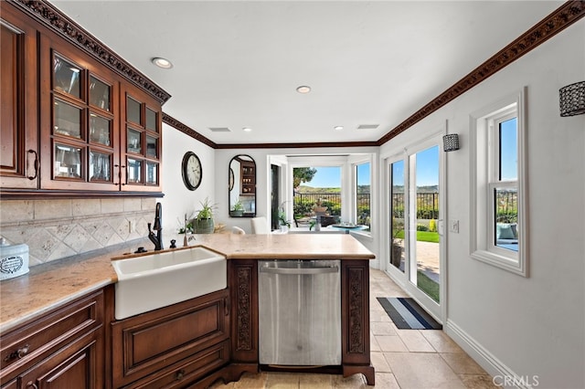 kitchen with a peninsula, glass insert cabinets, a sink, dishwasher, and tasteful backsplash