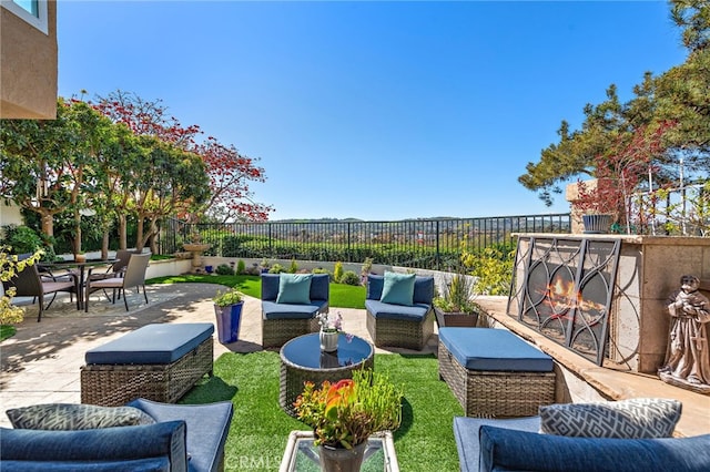 view of patio / terrace featuring a fenced backyard, an outdoor living space with a fireplace, and outdoor dining space