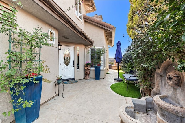 doorway to property with a patio and stucco siding