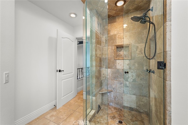bathroom with stone finish floor, baseboards, tiled shower, and recessed lighting