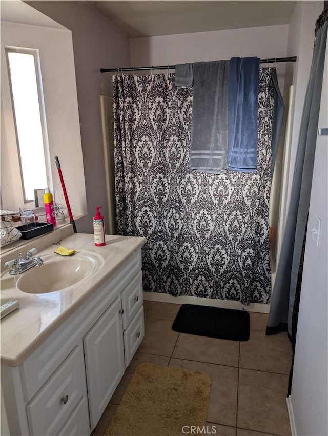 full bathroom with a shower with shower curtain, vanity, and tile patterned floors
