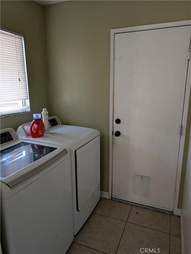 washroom featuring washing machine and clothes dryer, baseboards, laundry area, and light tile patterned floors