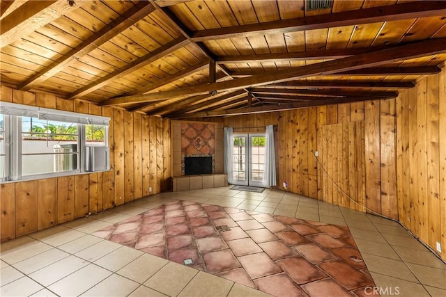 interior space featuring a large fireplace, wooden walls, and vaulted ceiling with beams