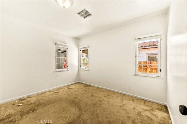 carpeted spare room with baseboards and visible vents