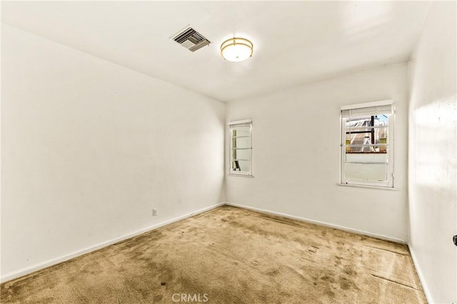 unfurnished room with visible vents, baseboards, and carpet
