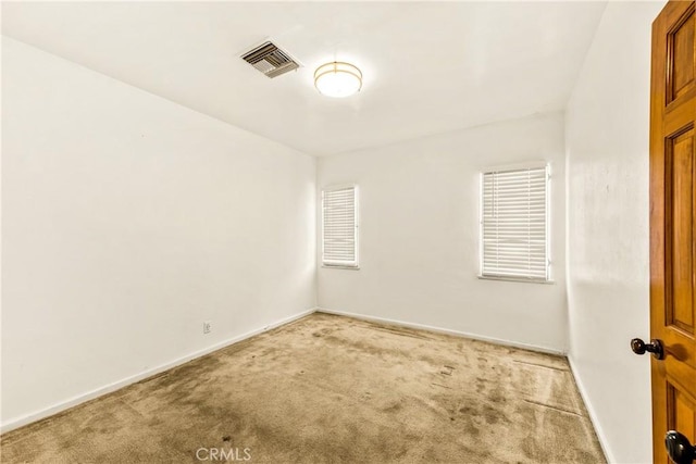 carpeted empty room with baseboards and visible vents