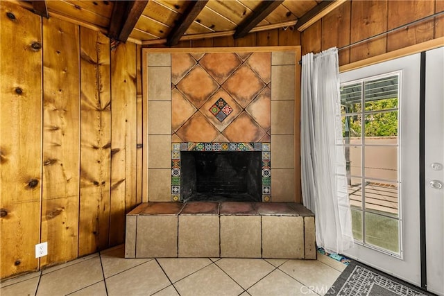 details featuring a tiled fireplace, beamed ceiling, wood walls, and wood ceiling