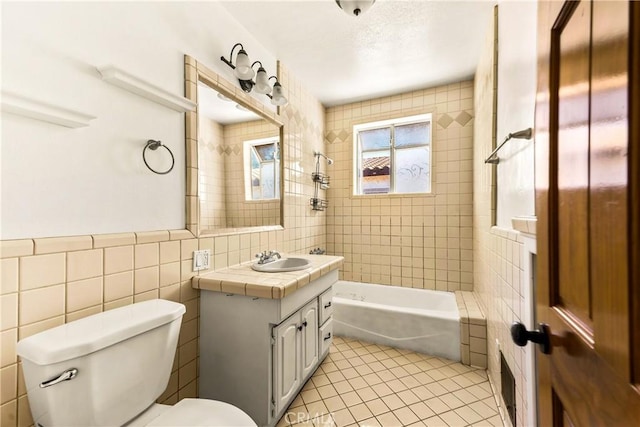 full bath with vanity, tile patterned floors, toilet, bathtub / shower combination, and tile walls