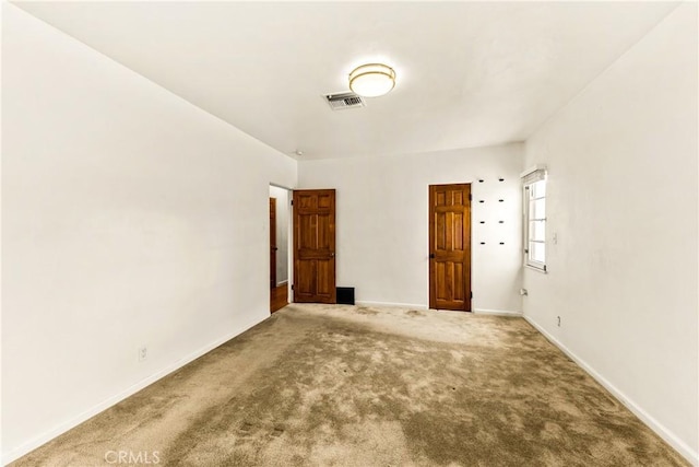 empty room with visible vents, baseboards, and carpet
