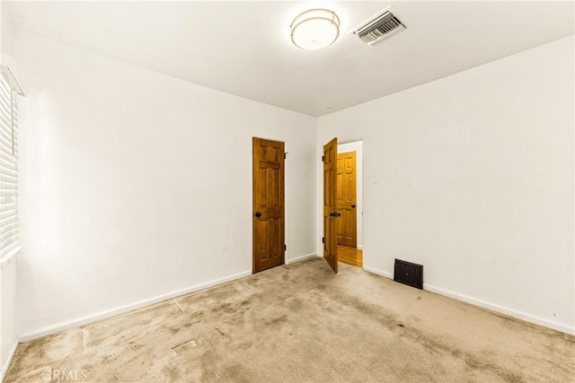 unfurnished room featuring baseboards, carpet, and visible vents