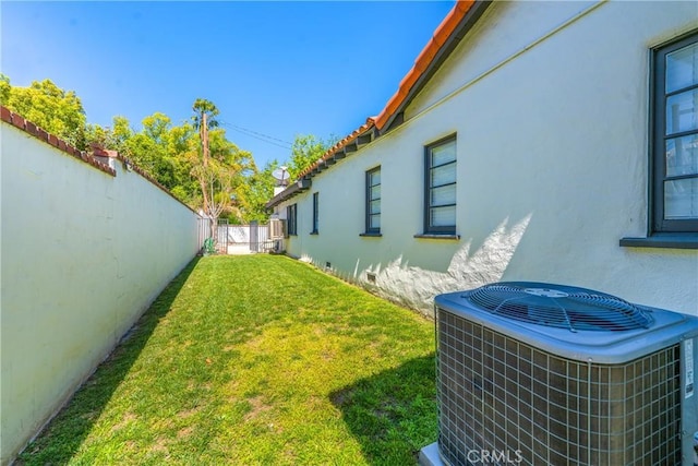 view of yard featuring a fenced backyard and central AC
