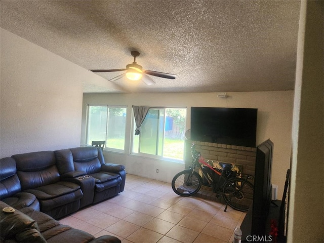 living room featuring a textured ceiling, ceiling fan, and light tile patterned floors