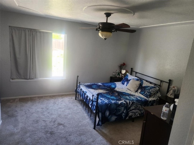 bedroom with a ceiling fan, carpet, and a textured ceiling