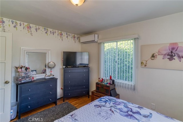 bedroom featuring wood finished floors and an AC wall unit