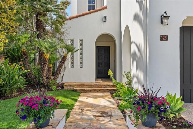 doorway to property featuring stucco siding