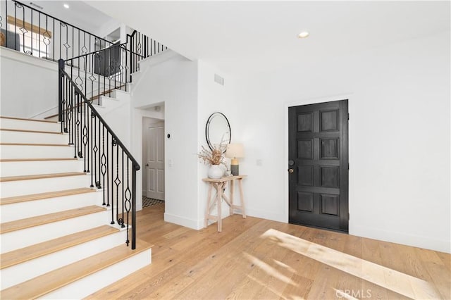 entrance foyer featuring baseboards, recessed lighting, hardwood / wood-style floors, and stairs