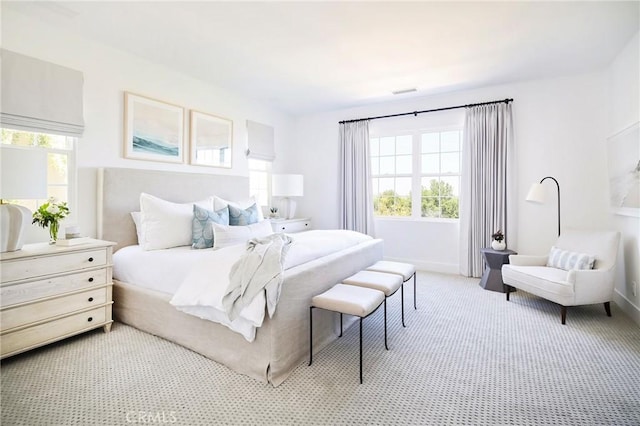 bedroom with light colored carpet and baseboards