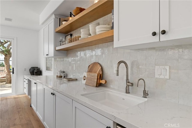 kitchen featuring a sink, decorative backsplash, open shelves, and white cabinets