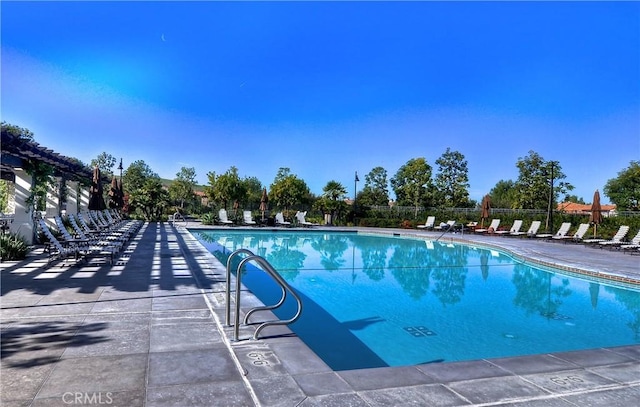 pool with fence and a patio