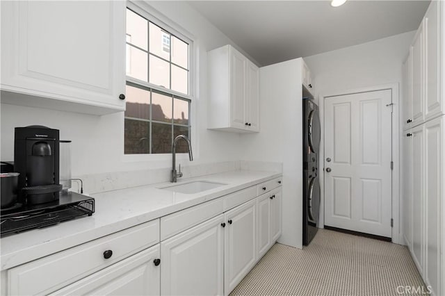 kitchen with a sink, white cabinets, recessed lighting, and light stone counters