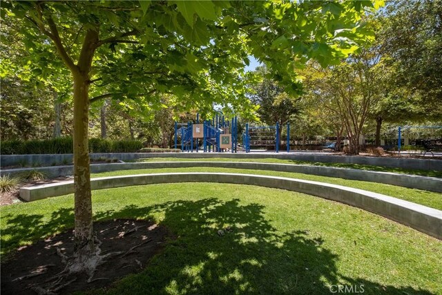 view of property's community featuring a yard, playground community, and volleyball court