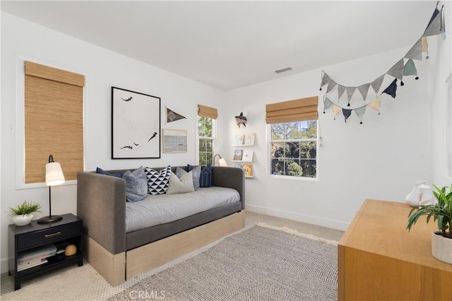 living area with visible vents, baseboards, and carpet