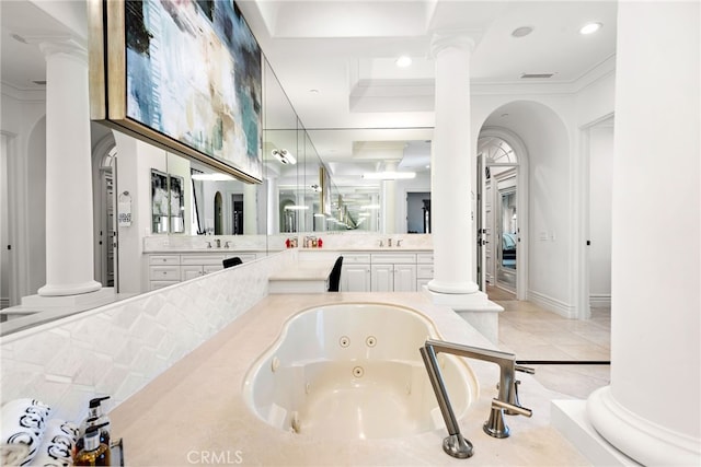 bathroom featuring a whirlpool tub, decorative columns, and vanity