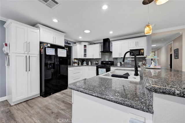 kitchen with wall chimney exhaust hood, ornamental molding, a sink, and black appliances