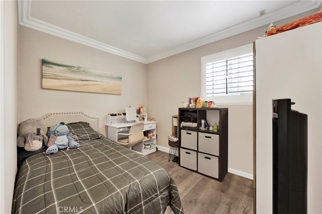 bedroom featuring baseboards, ornamental molding, and wood finished floors