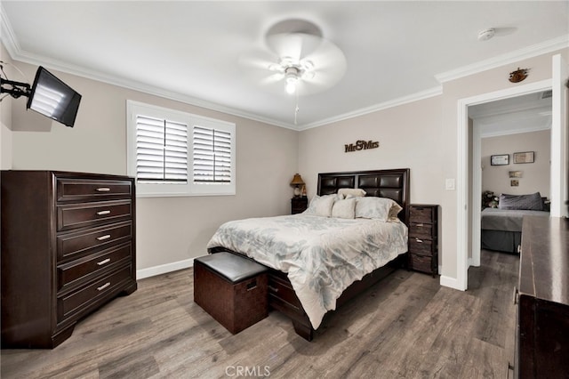 bedroom with ceiling fan, baseboards, crown molding, and wood finished floors