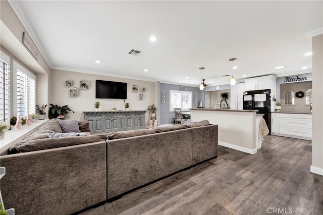 living area featuring visible vents, recessed lighting, dark wood-type flooring, and ornamental molding