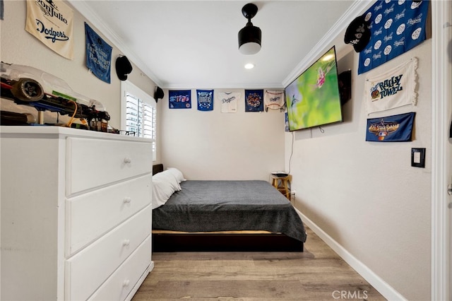 bedroom featuring baseboards, crown molding, wood finished floors, and recessed lighting