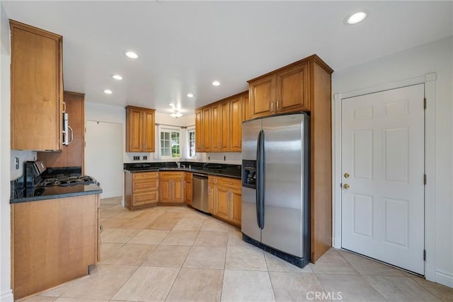 18342 Avolinda Dr, Yorba Linda, CA 92886 - kitchen with appliances with stainless steel finishes, dark countertops, brown cabinetry, recessed lighting, and a sink