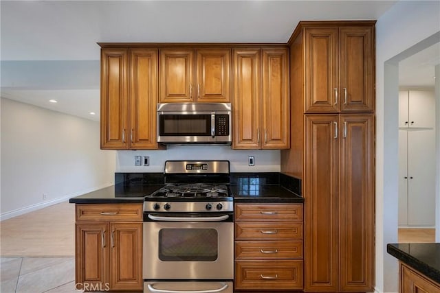 18342 Avolinda Dr, Yorba Linda, CA 92886 - kitchen featuring stainless steel appliances, brown cabinets, baseboards, dark stone countertops, and recessed lighting