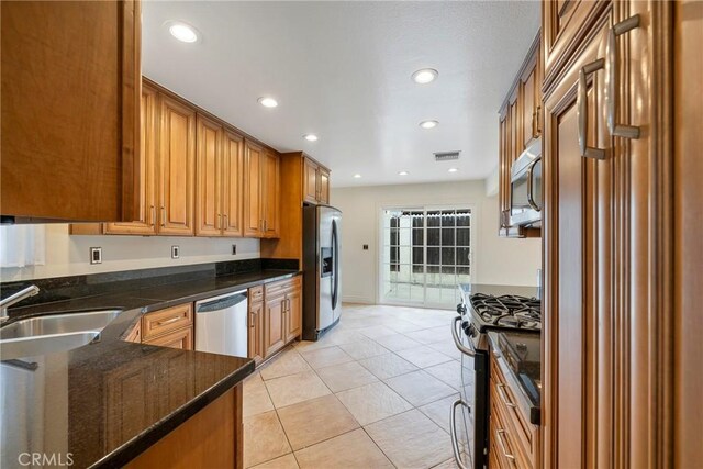 18342 Avolinda Dr, Yorba Linda, CA 92886 - kitchen with stainless steel appliances, a sink, brown cabinetry, light tile patterned floors, and recessed lighting