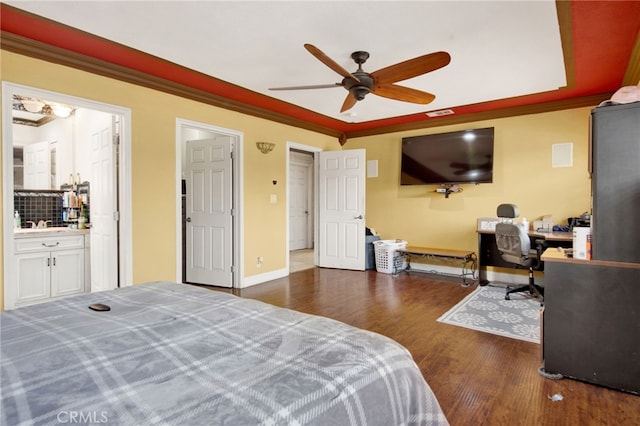 bedroom with wood finished floors, baseboards, and ornamental molding