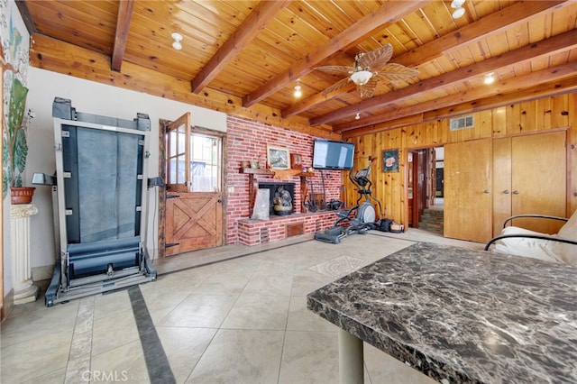 tiled bedroom with wooden walls, wood ceiling, a fireplace, beam ceiling, and visible vents