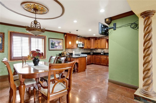 dining space with crown molding, baseboards, and decorative columns