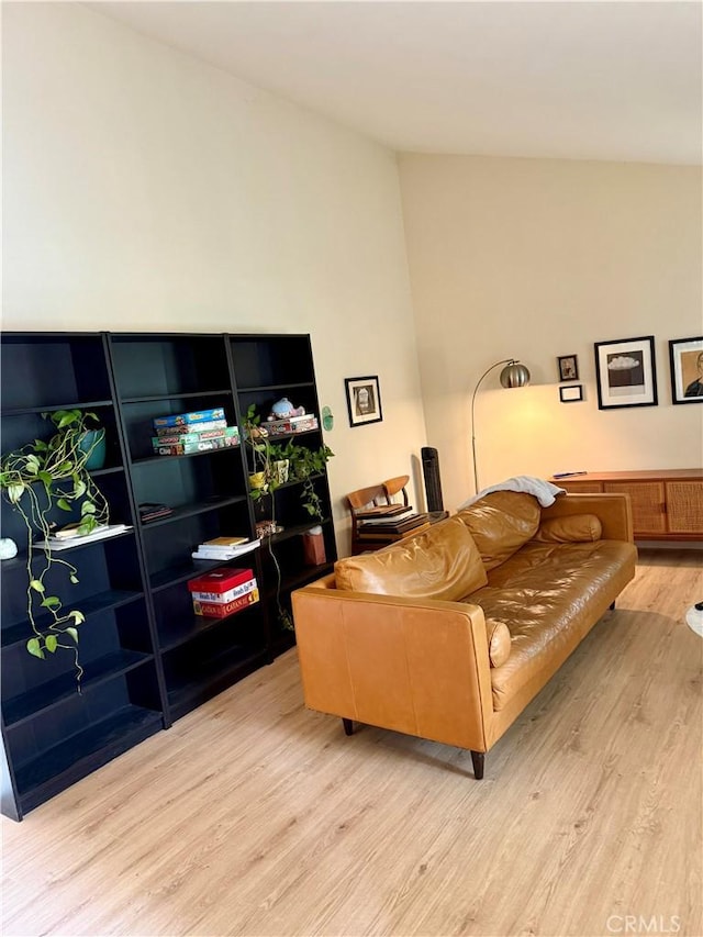 living area with lofted ceiling and wood finished floors