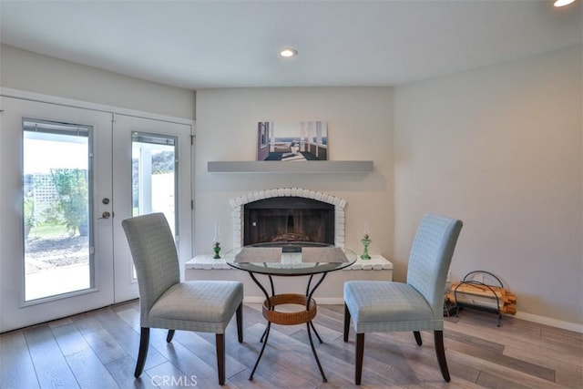 living area with french doors, recessed lighting, wood finished floors, and a fireplace