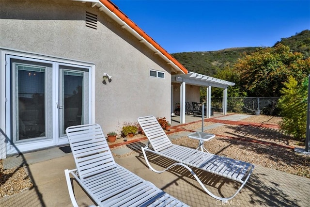 view of patio / terrace featuring a mountain view, fence, and a pergola