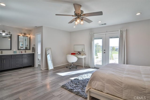 bedroom featuring access to outside, light wood-style floors, connected bathroom, recessed lighting, and french doors
