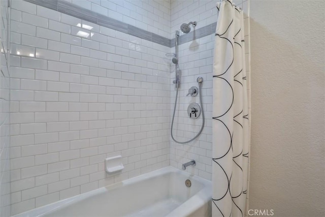 bathroom with shower / tub combo and a textured wall