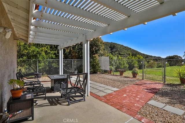view of patio with a mountain view, fence, and a gate